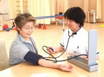 血圧測定する利用者と職員