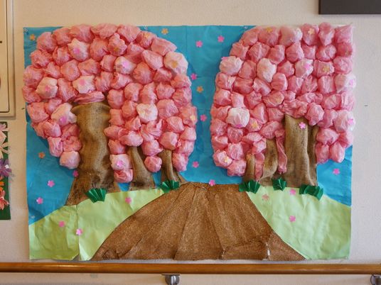 壁には入居者による作品が多数掲示されている。桜並木をモチーフにした貼り絵は、花びらの部分にポンポンを使っており迫力がある。