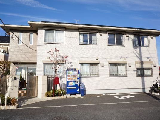 ガーデンコート前原東の建物の外観。それぞれの部屋に大きな窓が備わっている。周囲に高い建物もなく、青空が見える。