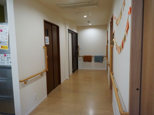 廊下は広く、両側の壁面には木製の手すりが備わっている。トイレなど、すべてのドアはスライド式になっている。