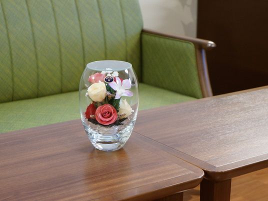 テーブルの上にはブレザーブドフラワーのアレンジメントが置かれている。とても華やかな雰囲気になっている。