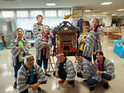 笑顔のスタッフと神輿のフロント
