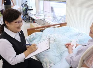 笑顔で話す女性と利用者の居室