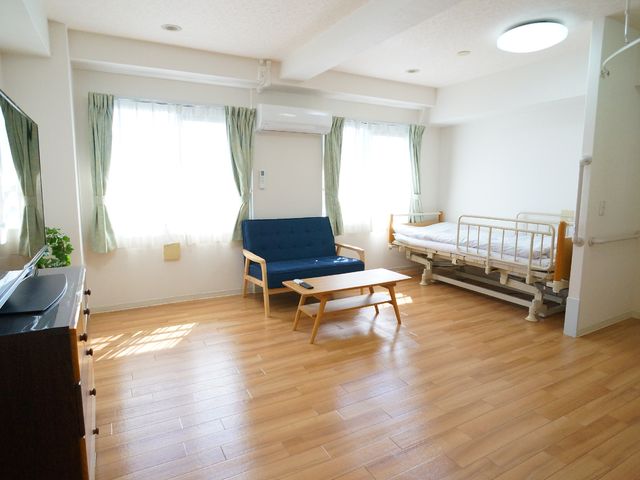 明るい広々居室 居室 日当たりが良く快適な居住スペースが確保されており、ゆったりとくつろげる環境です。温かみのある木目調の床が心地よい空間を演出しています。