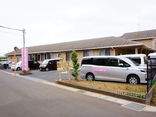 施設前の送迎車両と看板