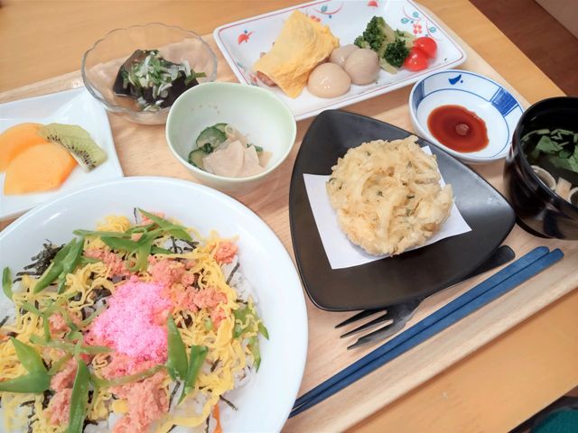 色とりどりの料理トレイ 食堂 見た目も鮮やかな食事が並ぶ食卓です。入居者の栄養バランスを考えた献立が特徴です。
