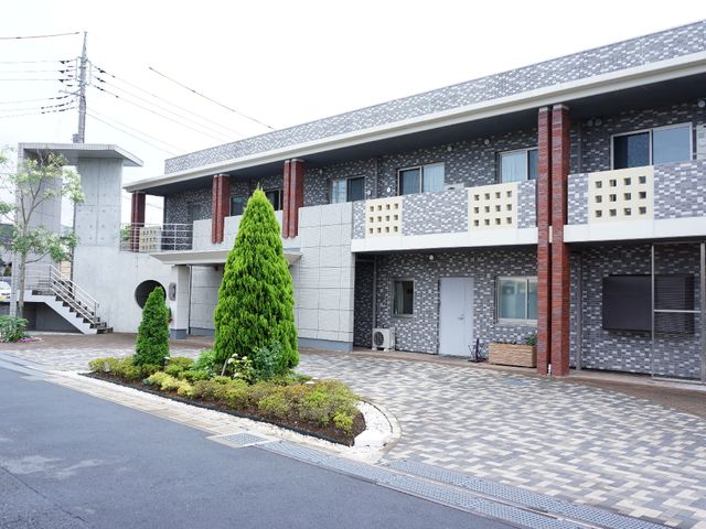 綺麗な外観の建物 施設外観 清潔感のある建物の前には、整備された緑の植栽があり、心地よい環境が広がっています。勤務するスタッフにとっても快適な職場です。