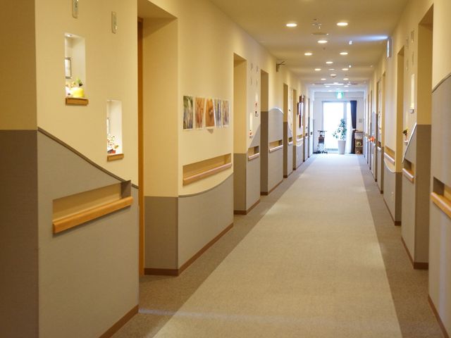 廊下の明るい空間 廊下 ゆったりとした廊下は明るく、壁には飾り棚やアートがあります。手すりも設置され、日々の生活の中で安全に移動できる環境が整っています。