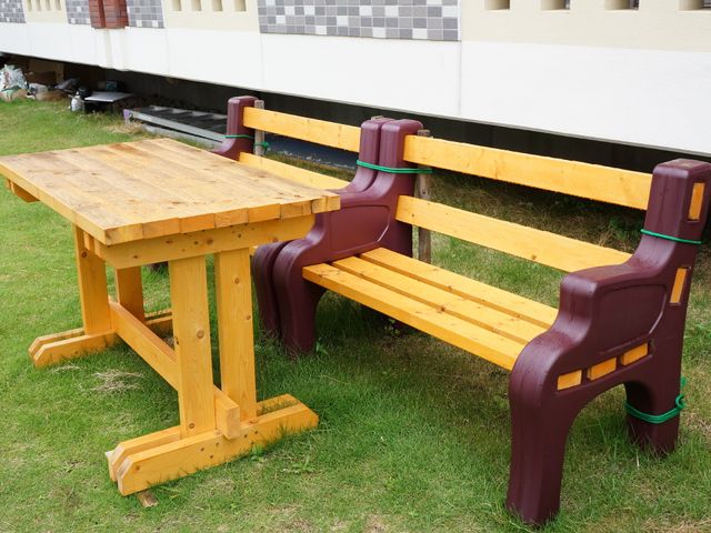 庭の木製ベンチとテーブル 庭 ゆったりとした時間を過ごす、庭にあるベンチとテーブルです。新鮮な空気と自然の中で、居心地の良いひとときを提供します。
