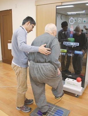 運動補助するスタッフと利用者の姿  
