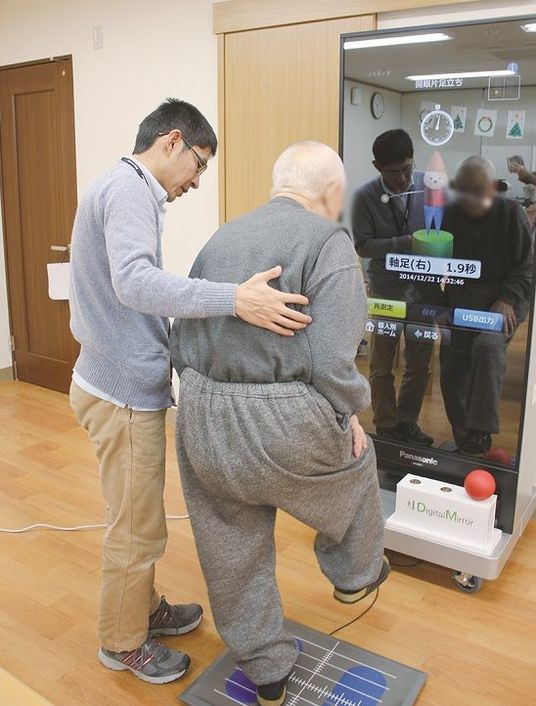 運動補助するスタッフと利用者の姿  