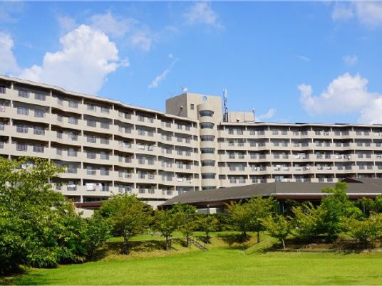 緑に囲まれた建物の外観  