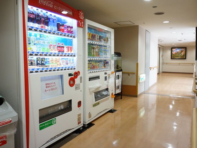 清潔感のある廊下 室内 自動販売機が設置された広々とした通路です。利用者の方がいつでも飲み物を手に取れる便利さが整っています。