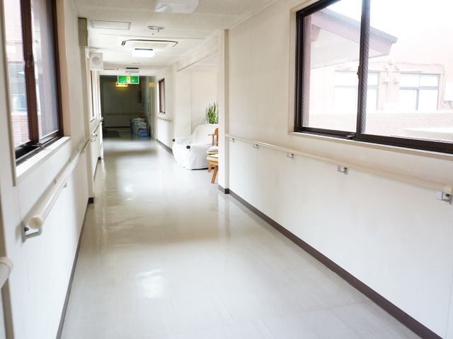 明るい施設の廊下 廊下 手すり設置で安全な空間。清潔で明るい通路が印象的です。
