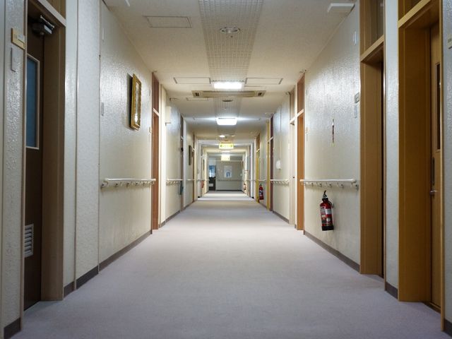 清潔な長い廊下 廊下 手すりが整備された明るい廊下が、訪れる方々を優しく迎えています。