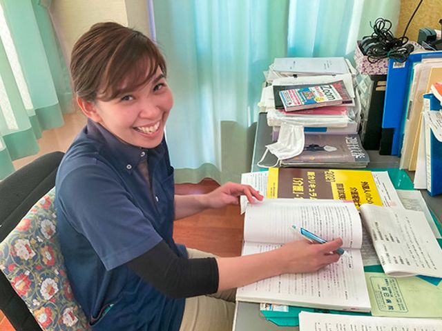 書類整理をする職員 スタッフイメージ 机で書類を整理している職員の様子です。明るい雰囲気で働くことができます。