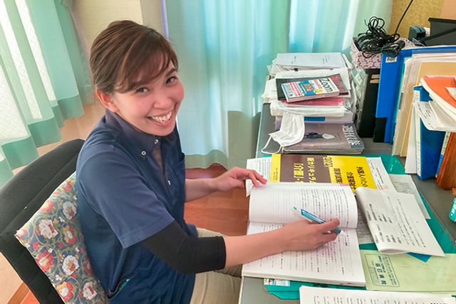 書類整理をする職員 スタッフイメージ 机で書類を整理している職員の様子です。明るい雰囲気で働くことができます。