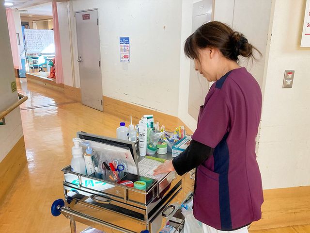 薬品の準備をする女性の廊下 廊下 明るい廊下で、スタッフが丁寧に薬品を整理しています。リラックスした雰囲気の中で働けます。