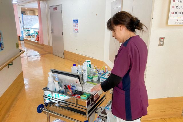薬品の準備をする女性の廊下 廊下 明るい廊下で、スタッフが丁寧に薬品を整理しています。リラックスした雰囲気の中で働けます。