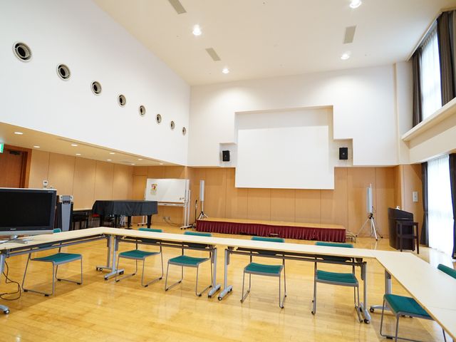 広々とした多目的室 共用スペース 天井が高く、窓から自然光が差し込む広々とした空間です。集会やレクリエーションに最適な環境を提供しています。