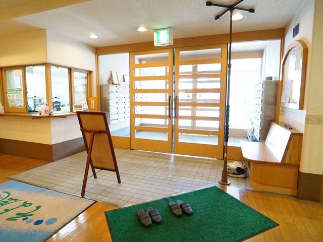 エントランスの明るい風景 受付 ゆったりとした空間のエントランスです。受付や掲示物が設置されており、訪れる方々を暖かく迎え入れます。