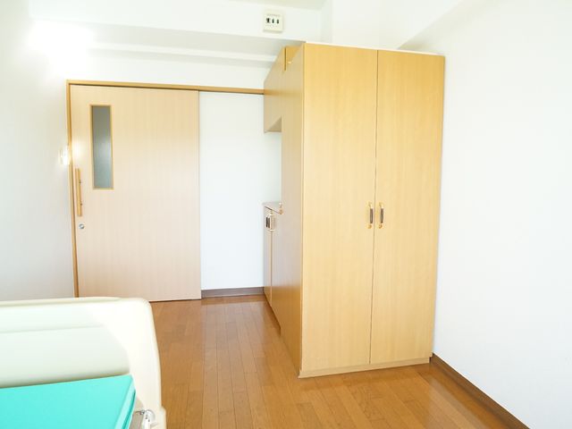 清潔な居室の一角 居室 ゆとりのある居室には、木目調の家具が配されており、落ち着きのある雰囲気です。快適な生活空間を提供するために工夫が凝らされています。