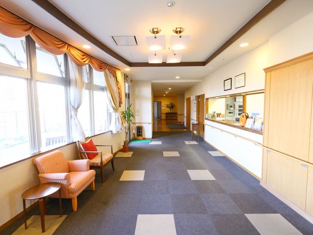 明るい廊下のロビー風景 ゆったりとした座席が並ぶ温もりのあるロビーです。訪れた方々がくつろげる心地よい空間が広がっています。