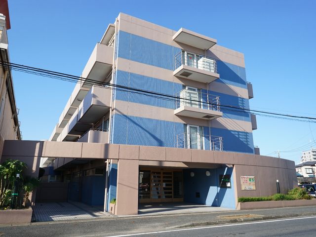 青空に映える多階層建物 外観 通り沿いに位置するモダンな建物です。清潔感があり、日当たりも良好な環境が広がっています。