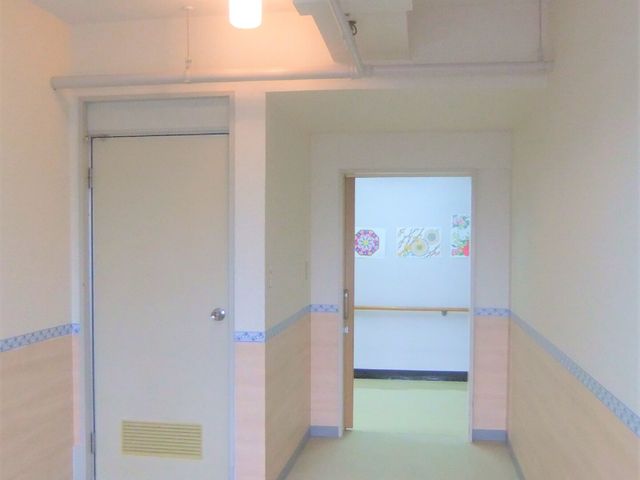 廊下の明るいイメージ Aタイプ居室 優しい色合いの壁と床が、温かみのある雰囲気を醸し出しています。