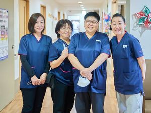 笑顔のスタッフ4人の廊下  