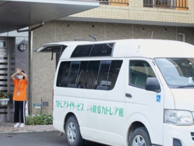 笑顔で手を振るスタッフ 外観 施設の前でスタッフが手を振り、訪れる人を親しみやすく迎えています。