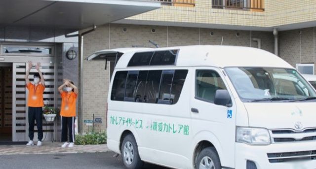 笑顔で手を振るスタッフ 外観 施設の前でスタッフが手を振り、訪れる人を親しみやすく迎えています。