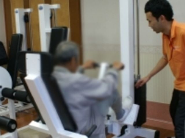機器を使って訓練する様子 機能訓練室 明るく開放的な空間で、専門スタッフが丁寧に指導している訓練の様子です。安心して日々のリハビリに取り組める環境を提供しています。