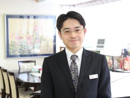 笑顔の男性スタッフ立つロビー