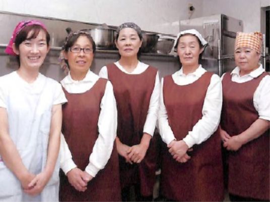 笑顔のスタッフ五人並ぶ厨房