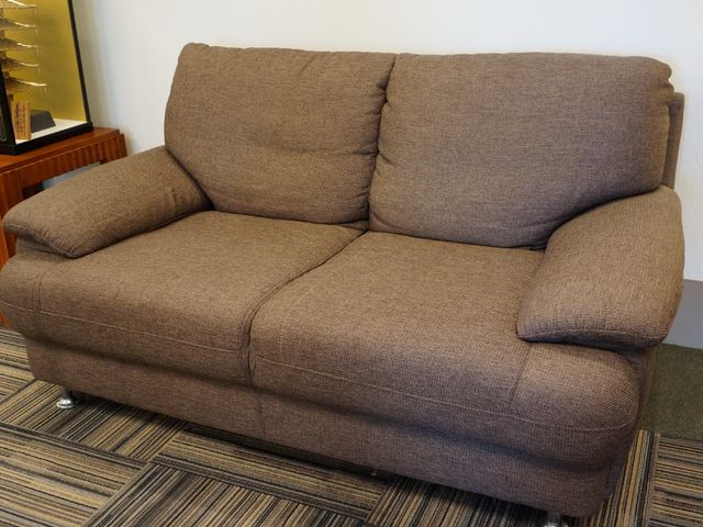 快適な茶色いソファ ソファ 落ち着いた色合いのソファが設置されており、ご家族や訪問者とのくつろぎの時間を提供します。ゆったりとした座面は長時間の使用にも適しています。