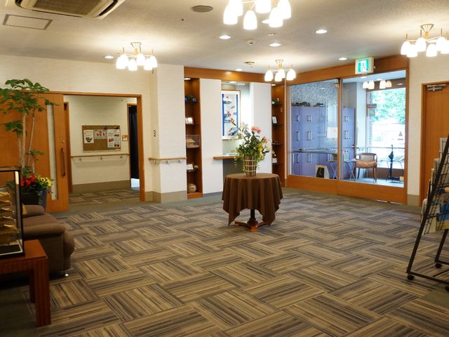 エントランスの広々とした空間 ロビー 暖かい照明が印象的なエントランスです。訪れた方々が自然とくつろげるような落ち着いた色合いのインテリアが配置されています。