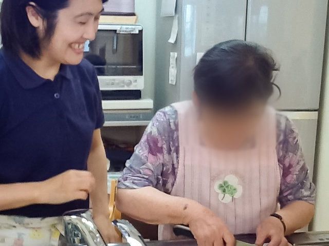 キッチン作業中の様子 キッチン 施設での調理活動の一場面です。職員と利用者が一緒に調理をしています。