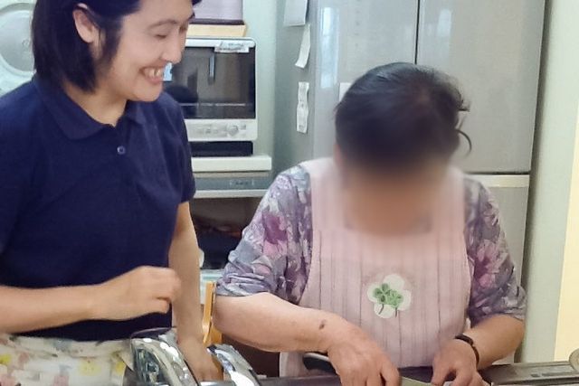 キッチン作業中の様子 キッチン 施設での調理活動の一場面です。職員と利用者が一緒に調理をしています。