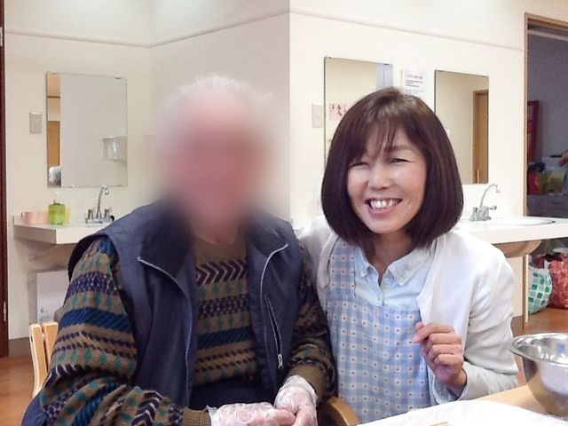笑顔のスタッフと利用者 リビング 開放的なリビングで、スタッフと利用者が和やかに触れ合っています。温かい雰囲気が広がります。