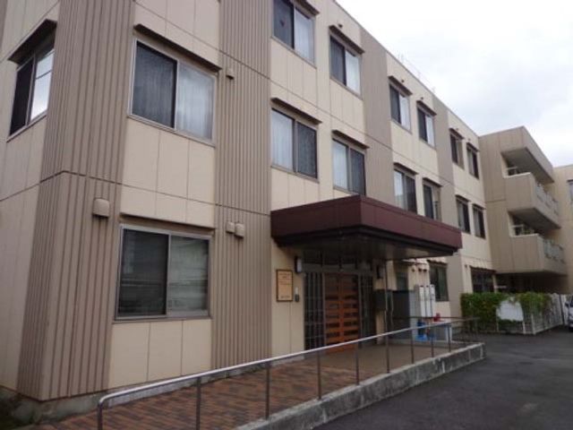 施設の外観とエントランス 外観 広々としたエントランスが迎えるゆとりの空間です。安全を考慮した手すりが設置されており、訪れる方々を優しくサポートします。