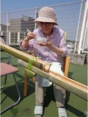 屋外で食事する高齢女性