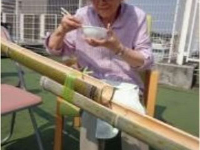 屋外で食事する高齢女性 レクリエーション 陽光の温もりの中、静かなテラスで心地よいひと時を過ごすことができ、自然を感じながらの食事が楽しめます。