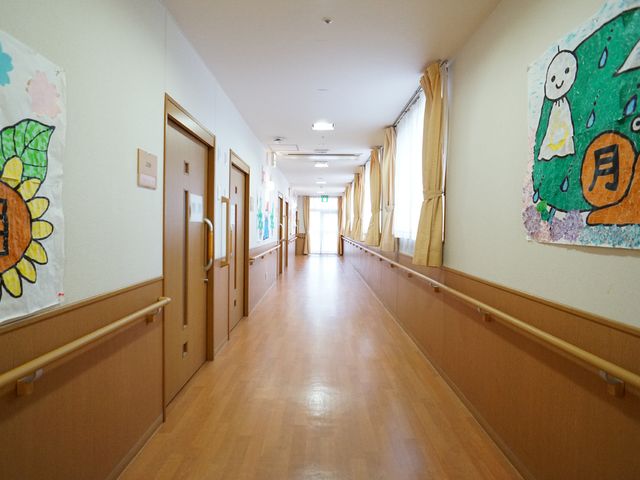 暖かみのある廊下 廊下 手すり付きの廊下は温かな色合いで、壁には楽しい絵が飾られ、居心地の良い空間を作り出しています。ここでは楽しみながら廊下を歩くことができそうです。