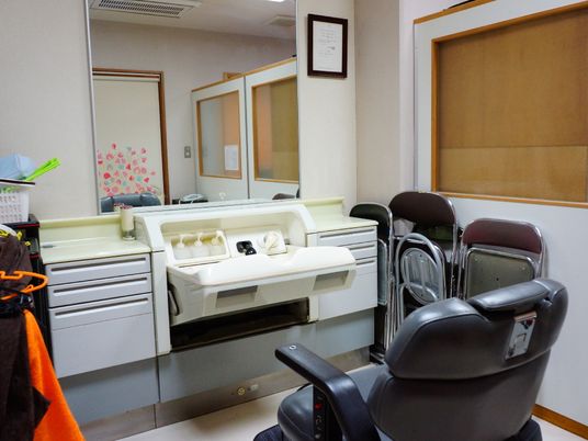 施設の写真 洗髪室には、黒い電動の椅子やシャワーが置いてあるので、スタッフが入浴困難な入居者様の洗髪をすることが出来る。