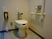 トイレは、全体的に白色で清潔感のあるデザインとなっている。壁に手すりや呼び出しボタンがあるので、安心して利用できる。