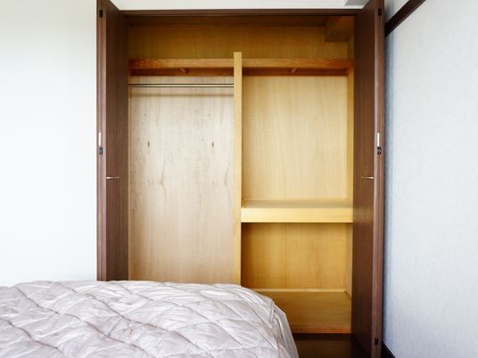 居室は、ベッドの足元側に木のデザインの収納棚が用意されている。ドアが両開きの作りになっているので、開きやすい。