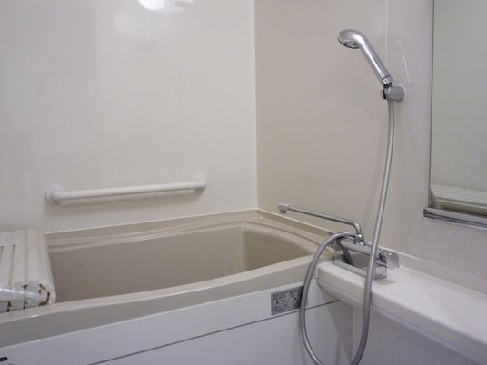 お風呂は、全体的に白の清潔感のあるデザインとなっている。壁に手すりがあり、安全に利用する事が出来る。