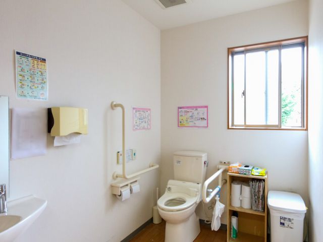 手すり付きのトイレ トイレ 広々としたトイレには、安全のための手すりが設置されており、使いやすく配慮されています。清潔感のあるこの空間は、日々の快適さを支えます。