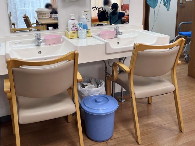 洗面台の様子 洗面台 明るく整えられた洗面台で、ケアの準備が充実しています。利用者同士の交流も見られます。